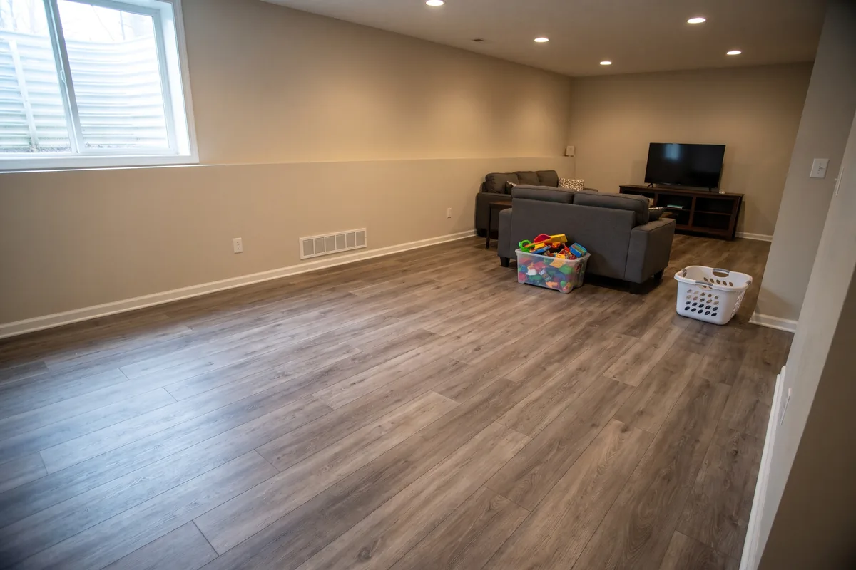 Gray-brown vinyl plank flooring in a finished basement family room