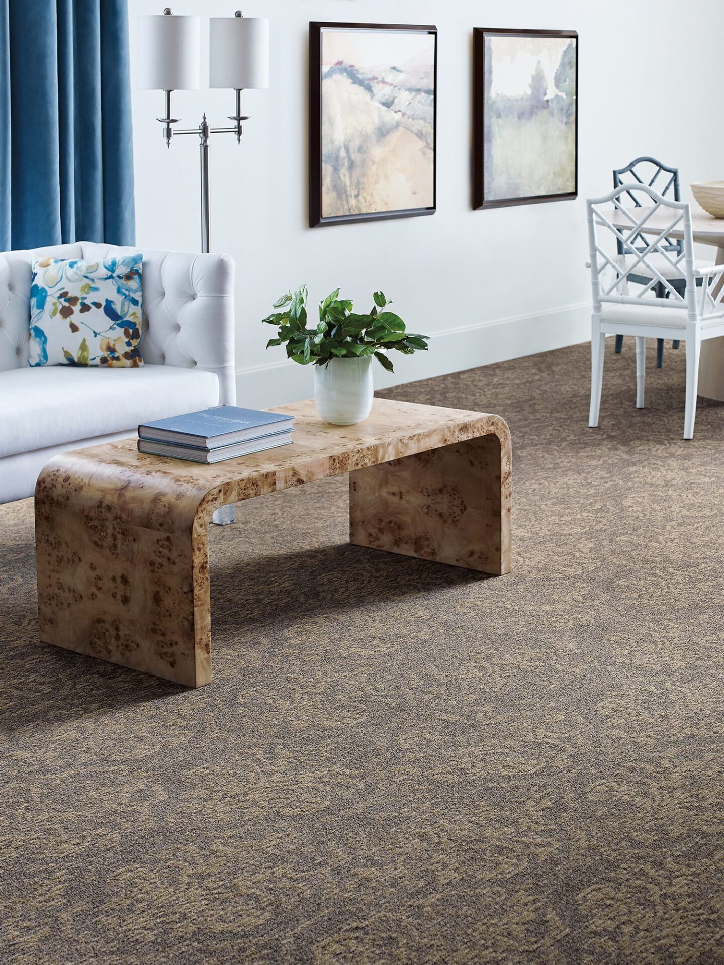 Taupe patterned carpet in a bright sitting room with a white sofa, wood coffee table and framed art