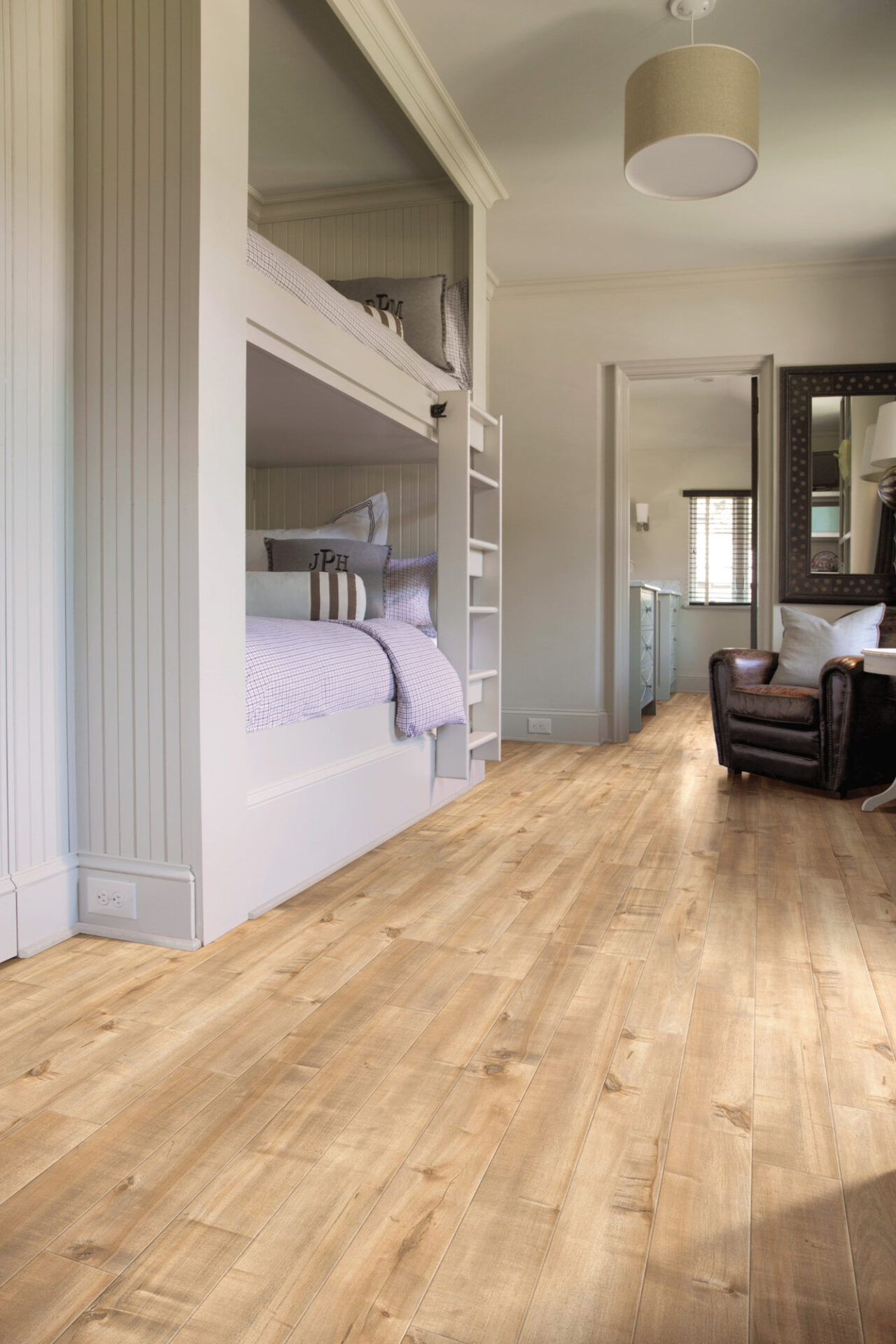 Natural oak-look laminate flooring in a bedroom with built-in bunks and a hallway beyond