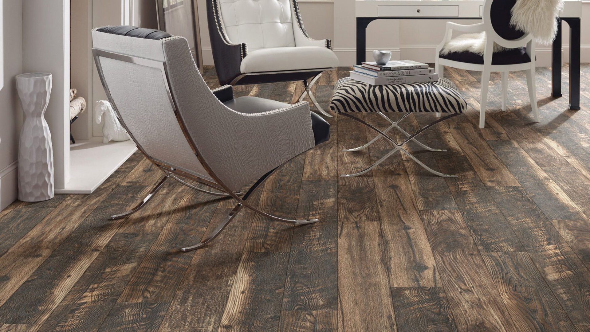 Multi-tone dark brown wood-look laminate flooring in a modern lounge with gray lounge chairs