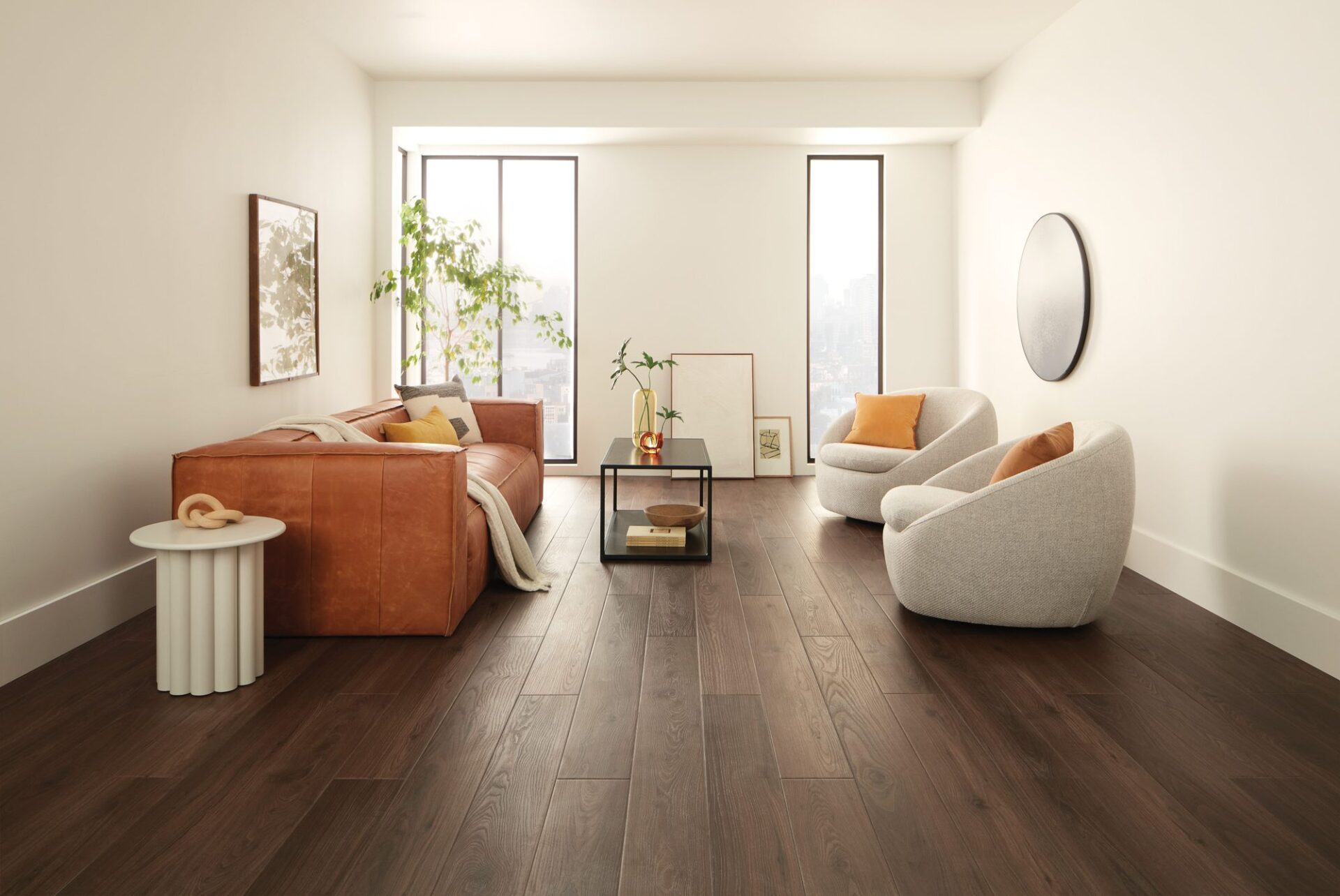 Dark brown wood look vinyl plank in a bright living room with a rust sofa and white accent chairs