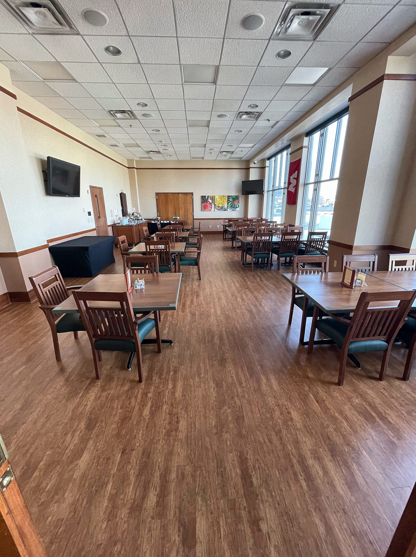 Wood-look commercial luxury vinyl tile flooring in a large club dining room with tables