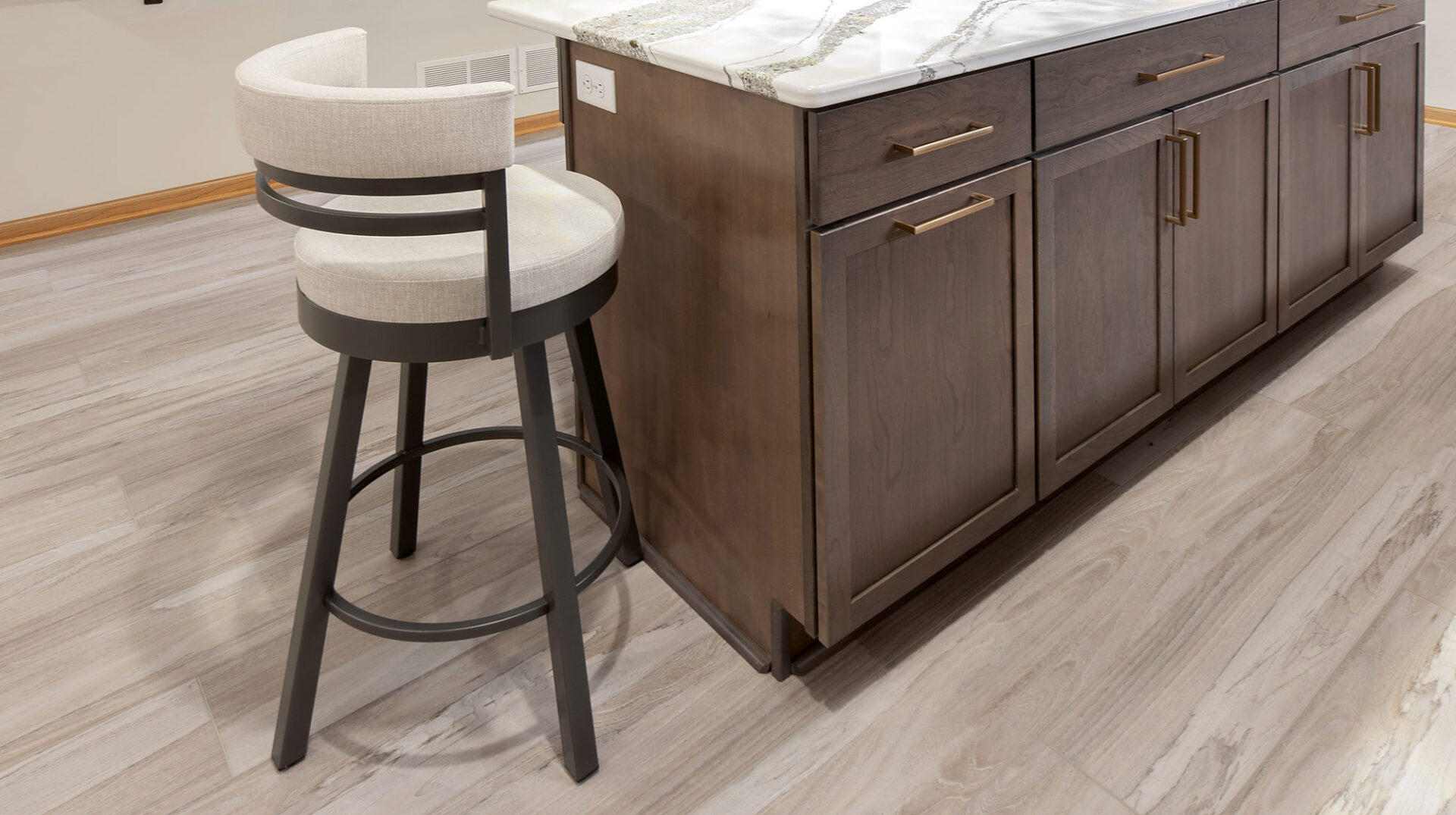 Light gray wood-look vinyl plank flooring around a kitchen island in a finished basement