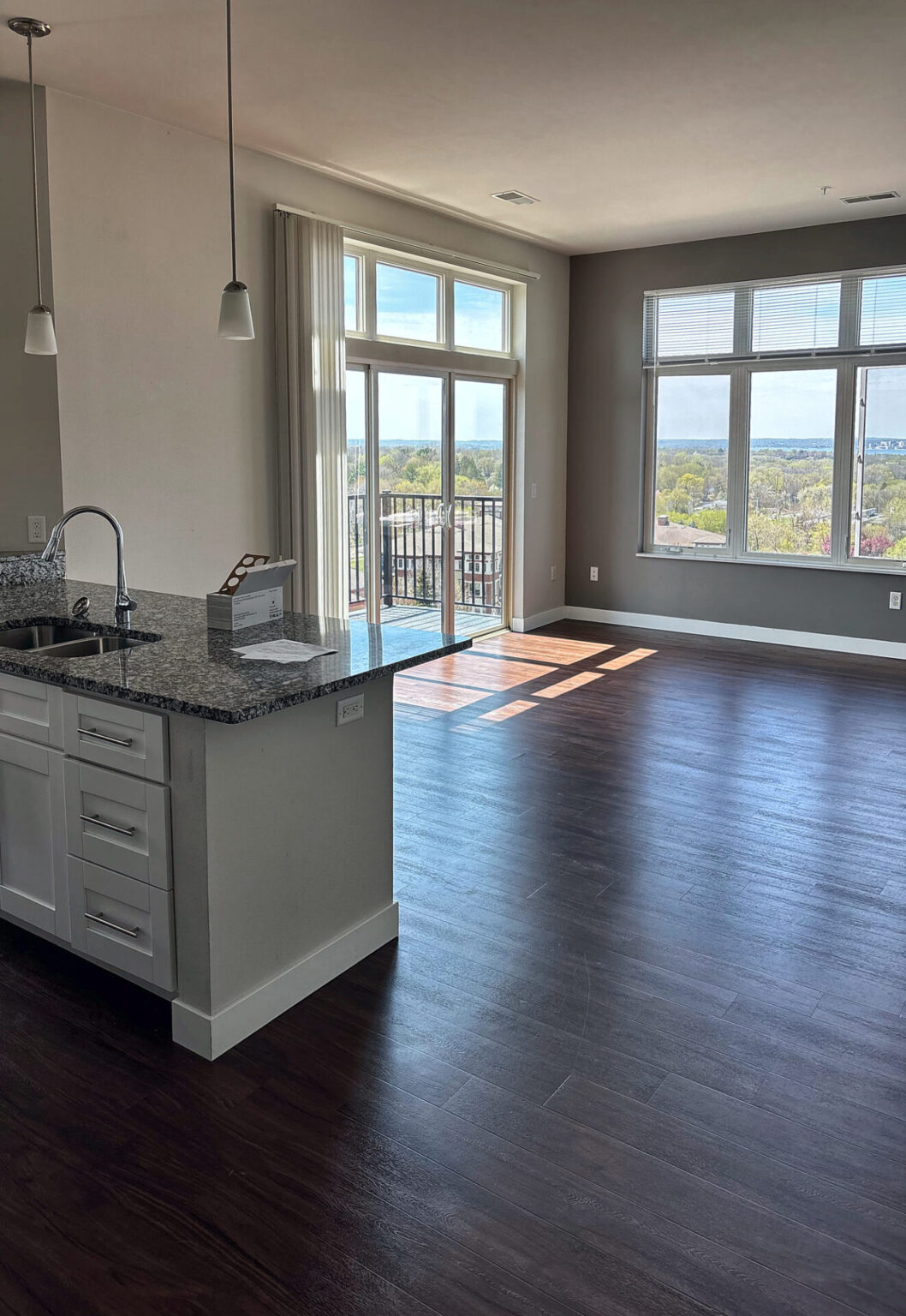 Dark walnut look luxury vinyl plank flooring in an open kitchen and living room, the kind of look COREtec is known for